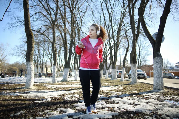 Girl walking in the park and listening music