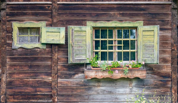Old alpine hut - window with flowers