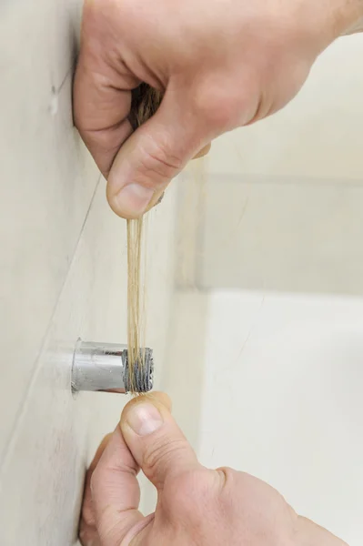 Plumber putting hemp fibers