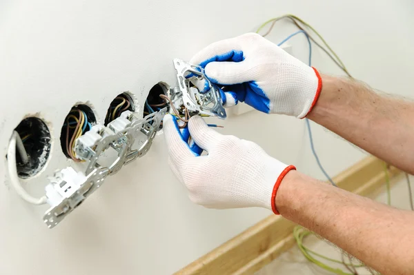 Electrician installs electrical outlets.