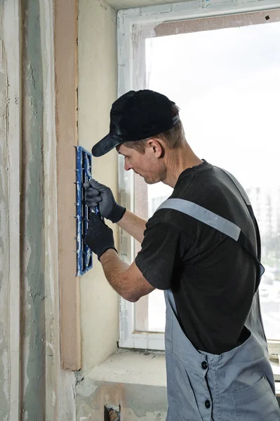 Worker with plaster rasp