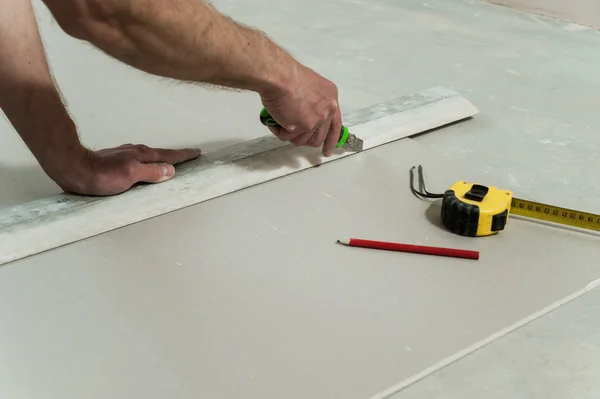 Man cuts off a piece of drywall