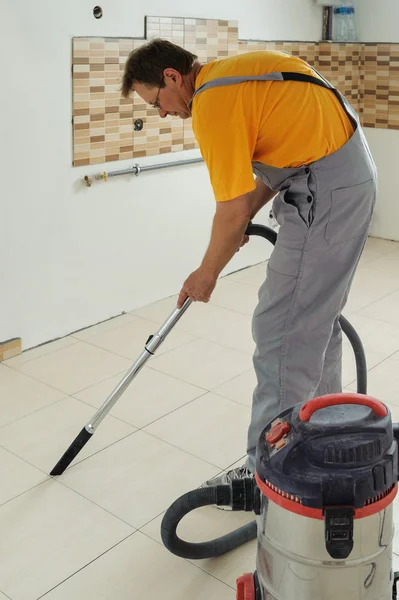 Worker cleans seams between tiles
