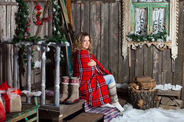 Girl about Christmas porch covered with a heated blanket