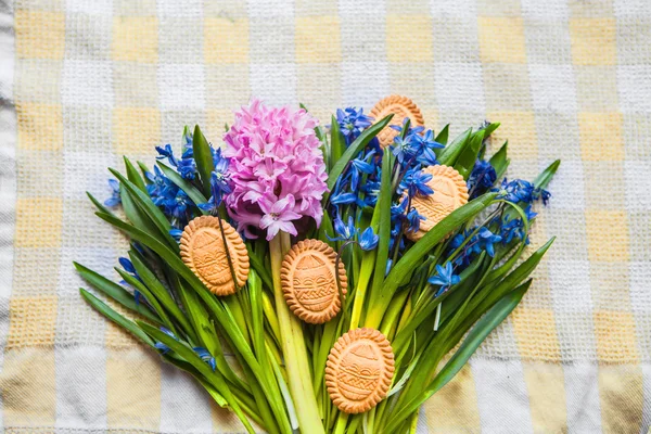 Top view of cookies in the shape of Easter eggs lie on scilla colors on yellow kitchen towel