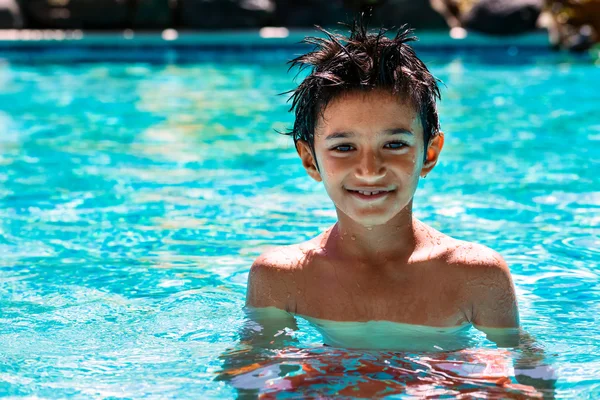 Boy kid child eight years old inside swimming pool portrait happy fun bright day