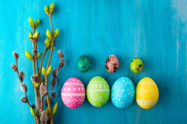 木制的桌子上鲜艳的色彩画复活节彩蛋 - 图库照