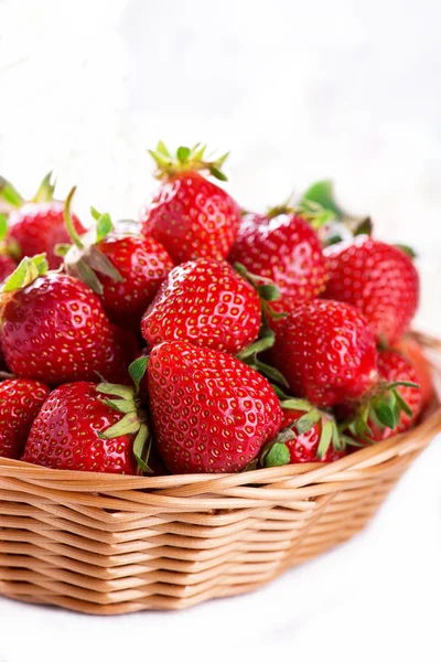 Fresh strawberry harvest in the basket, isolated on white