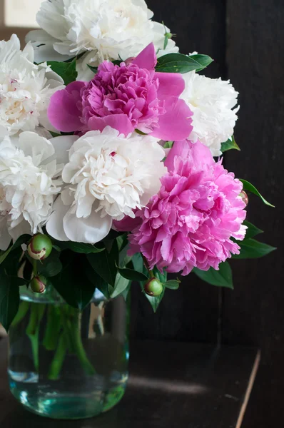 White and pink peonies on wooden background