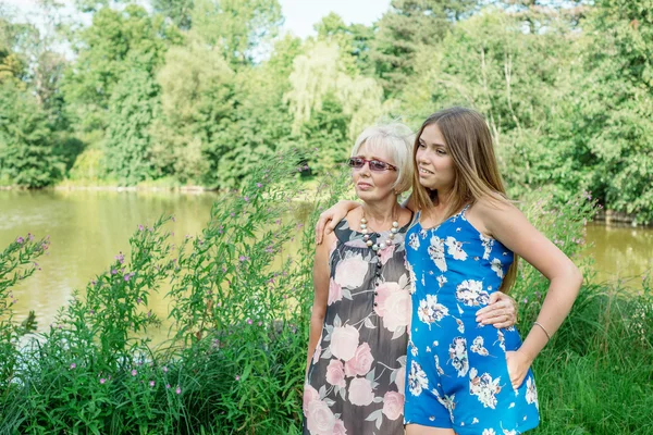 Grandmother and granddaughter walk in nature
