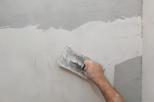 Worker spreading plaster to wall
