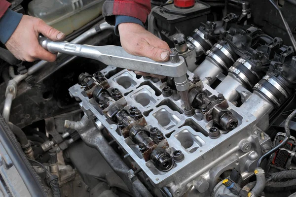 Automotive, cylinder head servicing, mechanic hands and tool