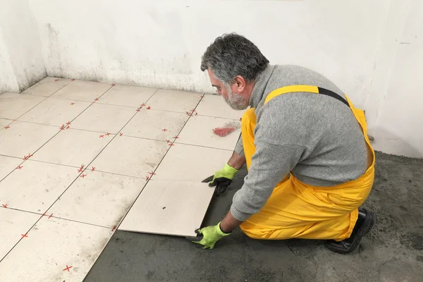 Home renovation, worker placing tile