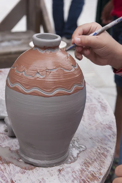 Decorating a wet clay pot