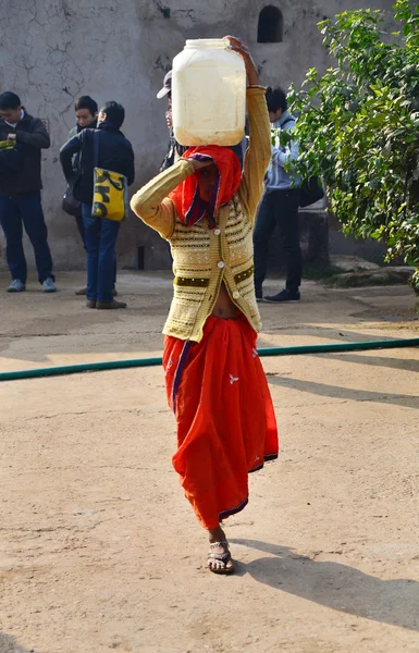 Jaipur, India - December 30, 2014: Local women carry their everyday load on their head in Jaipur, India.