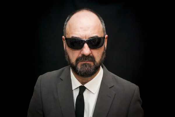 Handsome business man, bald and beard, with sunglasses over blac