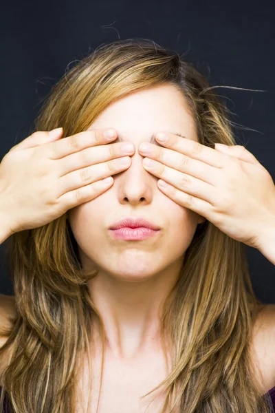 Portrait of a beautiful woman  covering her eyes with her hands
