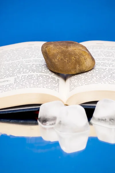 Book open with a single stone on it