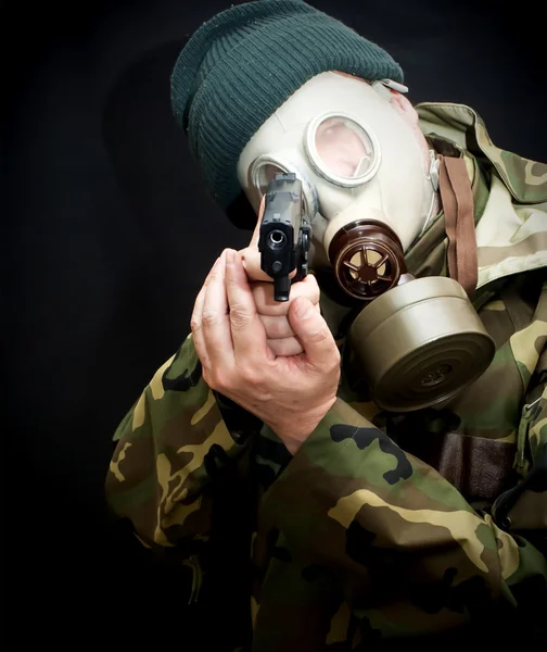Soldier with a gun, gas mask and camouflage suit