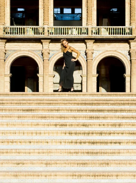 Beautiful woman on stairs in a monumental area