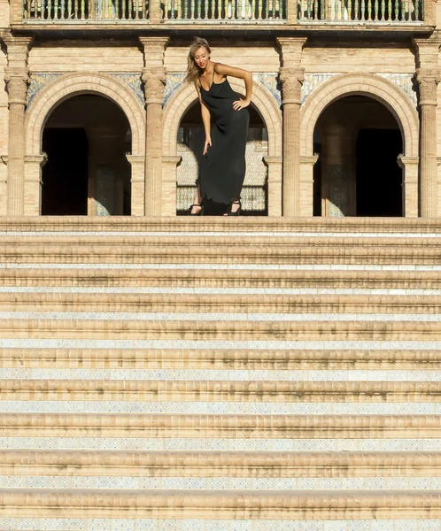 Beautiful woman on stairs in a monumental area