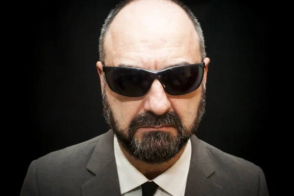 Handsome business man, bald and beard, over black