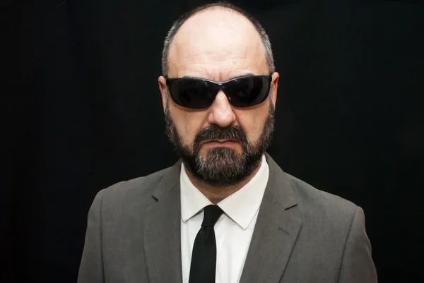 Handsome business man, bald and beard, over black