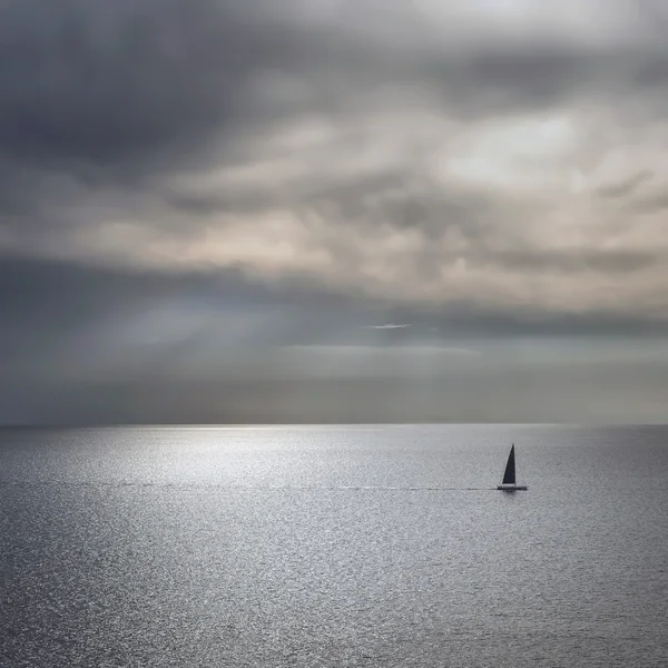 Ocean sea sunset view and black sail boat. Mediterranean sea. It