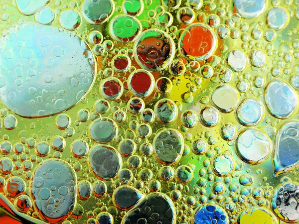 Olive oil bubbles in water close up