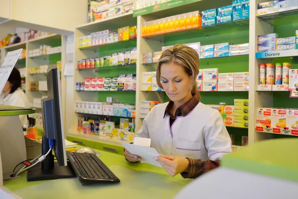 Female pharmacist holding prescription