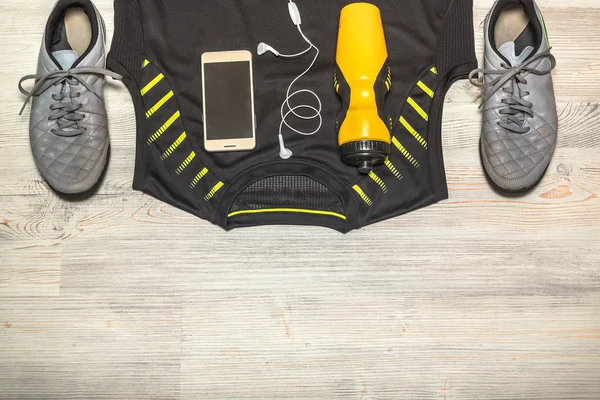 Fitness concept with mobile phone, earphones and Sport shoes ove