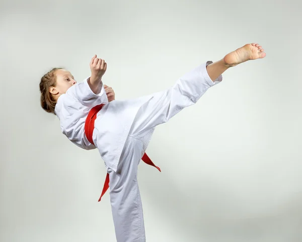 Girl with red belt strikes a high kick