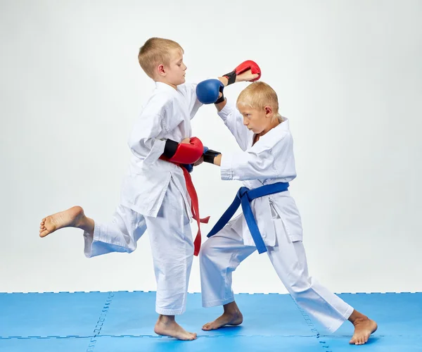 With blue and red overlays on his hands athletes train paired exercises karate