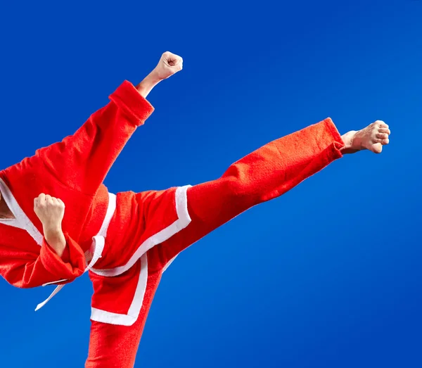 Sportswoman dressed as Santa Claus hits a high kick
