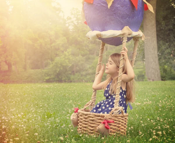 Child Pretending to Fly in Hot Air Balloon Outside