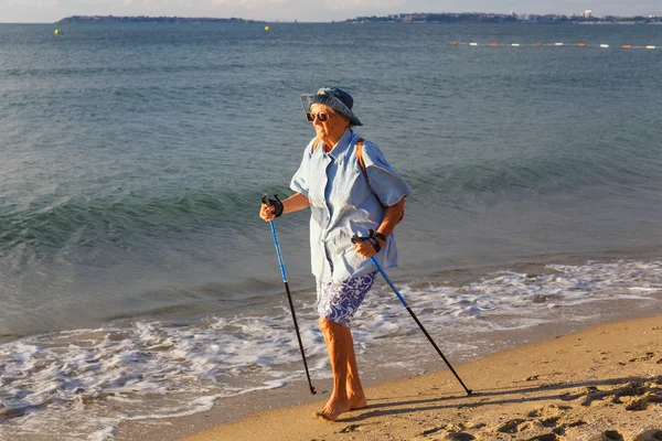 Two elderly woman practicing Nordic walking