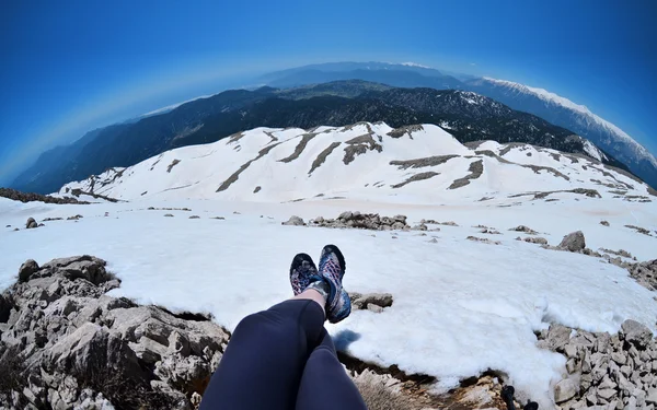 Legs of traveler sitting on a high mountain top in travel,Turkey