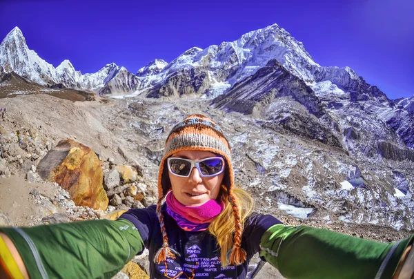 Smiling young woman takes a selfie  on mountain peak ,Everest region, Nepal