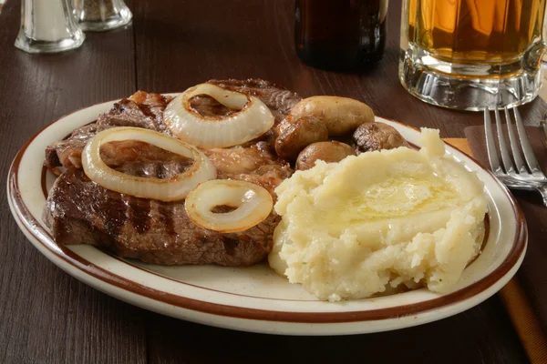 Steak and potatoes with beer