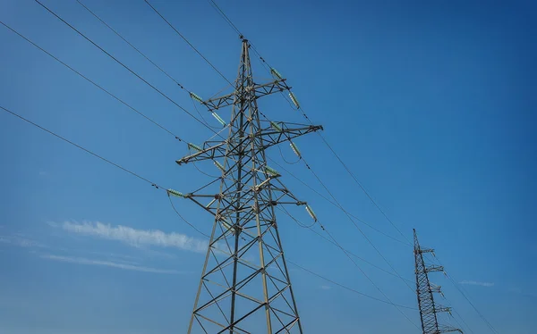 High-voltage tower on blue sky background.