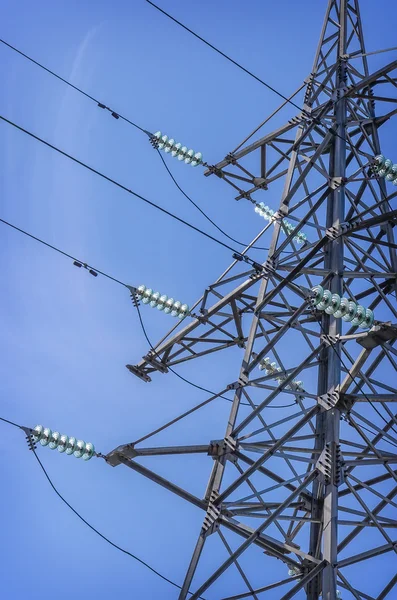 High-voltage tower on blue sky background.