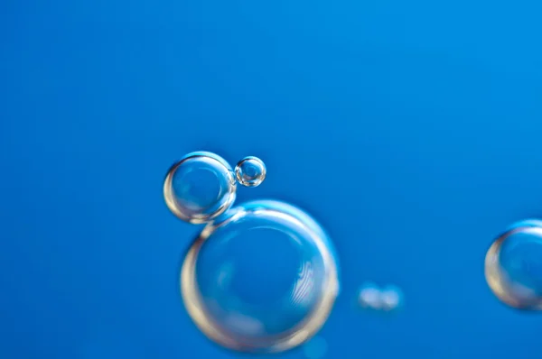 Close-up bubbles under water on blue background. Macro.