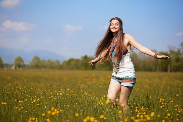Smiling hippie in summer flowers field