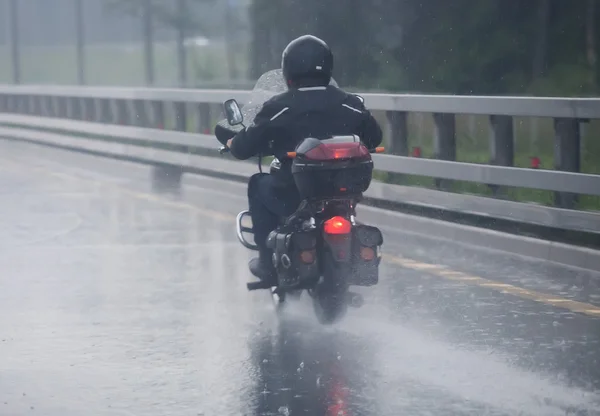 Motorcyclist moves on motorcycle to rainy weather