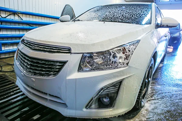 Car covered with foam in car wash
