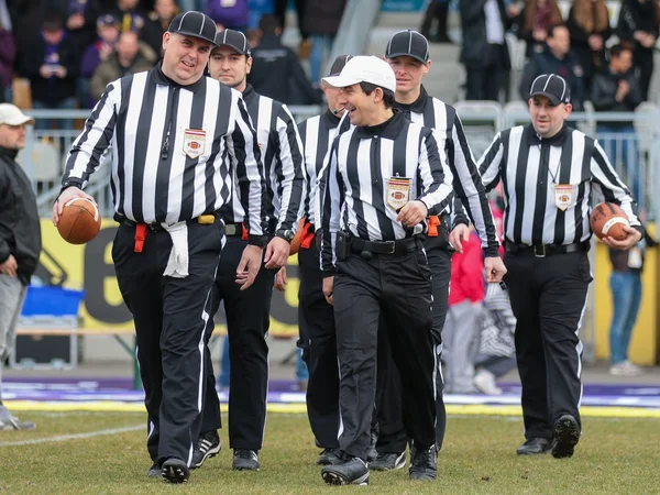 The referee crew walks on the field before a game