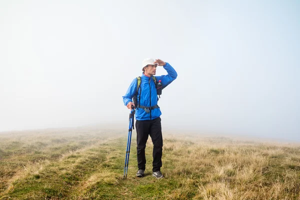 Man looking for his path in the fog