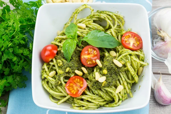 Square bowl of pasta with green pesto