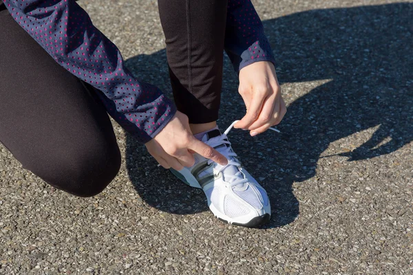 Woman tying her shoe laces