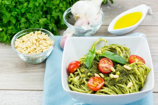 Square bowl of pasta with green pesto